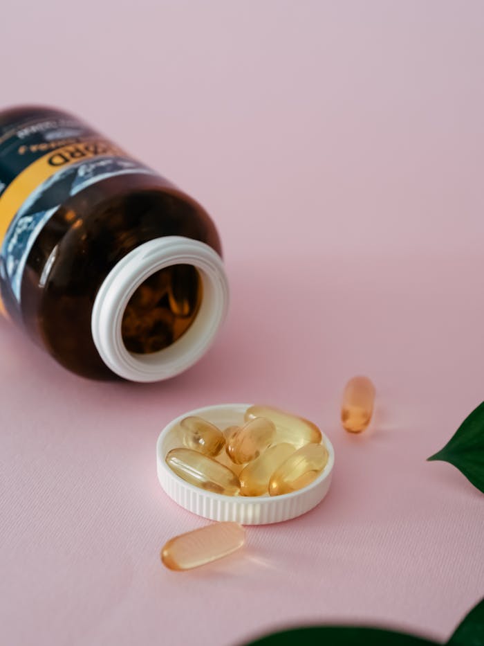 why-choose-us Cod liver oil capsules with bottle on pink backdrop, offering a healthcare focus.