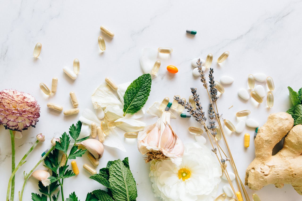 services-01 A flatlay of natural herbs, supplements, and flowers on a marble background.